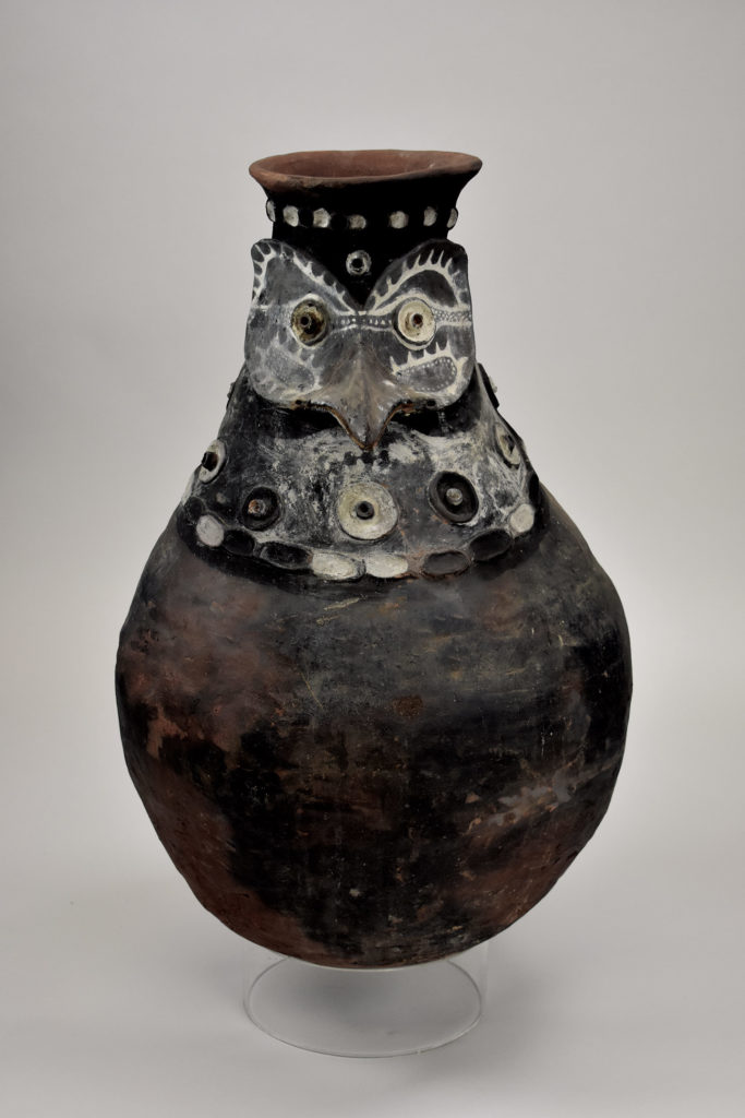 A ceramic jar with a bird effigy