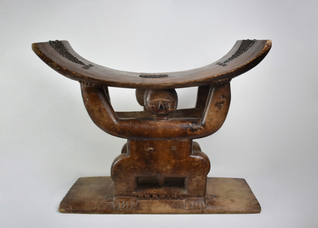 A wooden stool decorated with the shape of a man