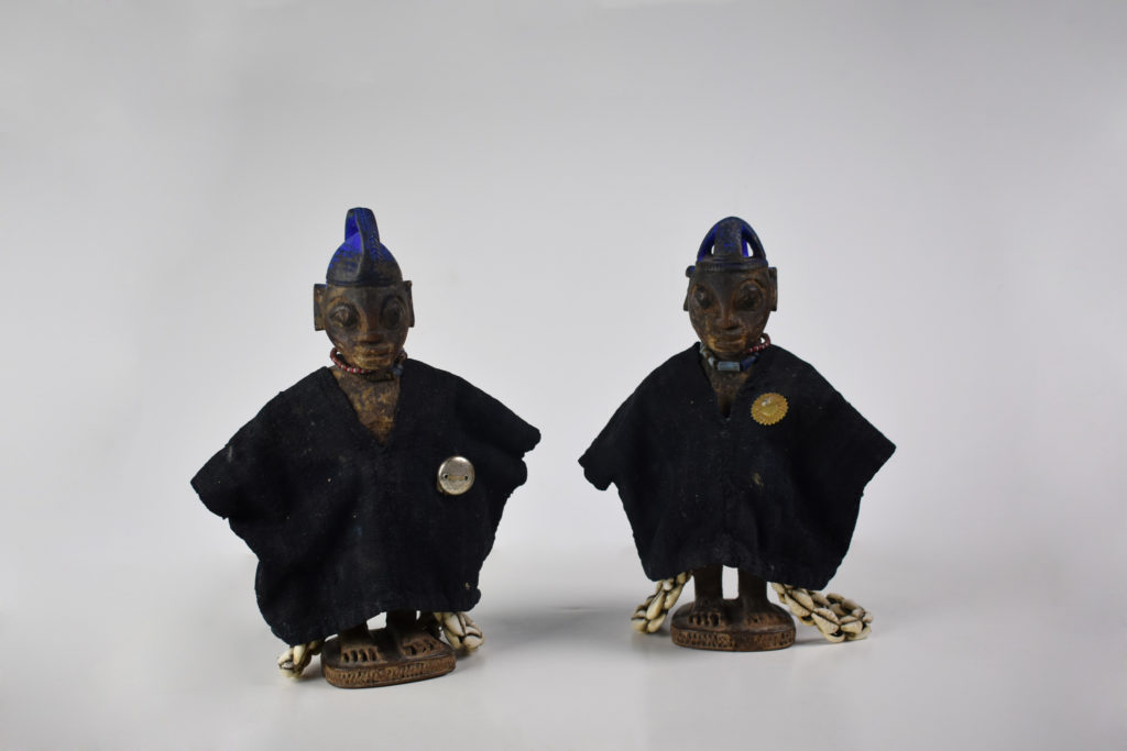 A pair of small, wooden human effigies from Nigeria known as Ere Ibeji