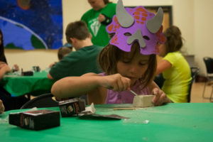 A young girl "digs" for dino bones